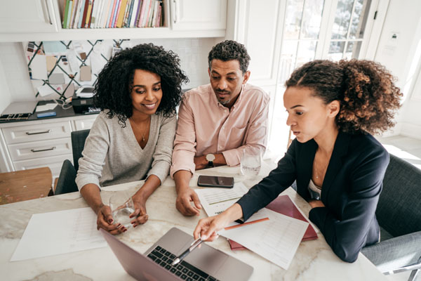 a man and two women looking at a laptop