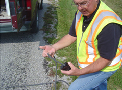 Road & Bridge employee holding a traffic counter