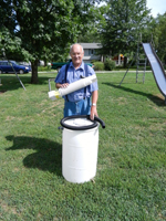 a volunteer preparing a rain barrel for installation