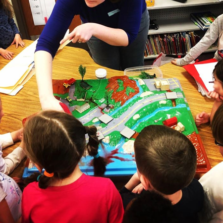 children looking at a tabletop enviroscape diorama